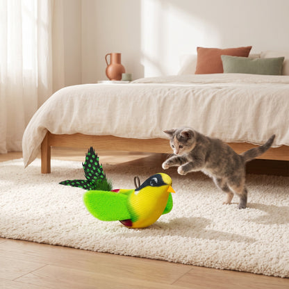 Chaton qui joue avec l'oiseau sonore vert